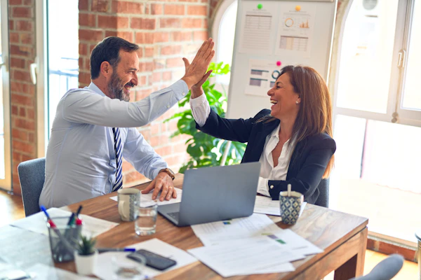 Sócios comemorando em reunião de trabalho